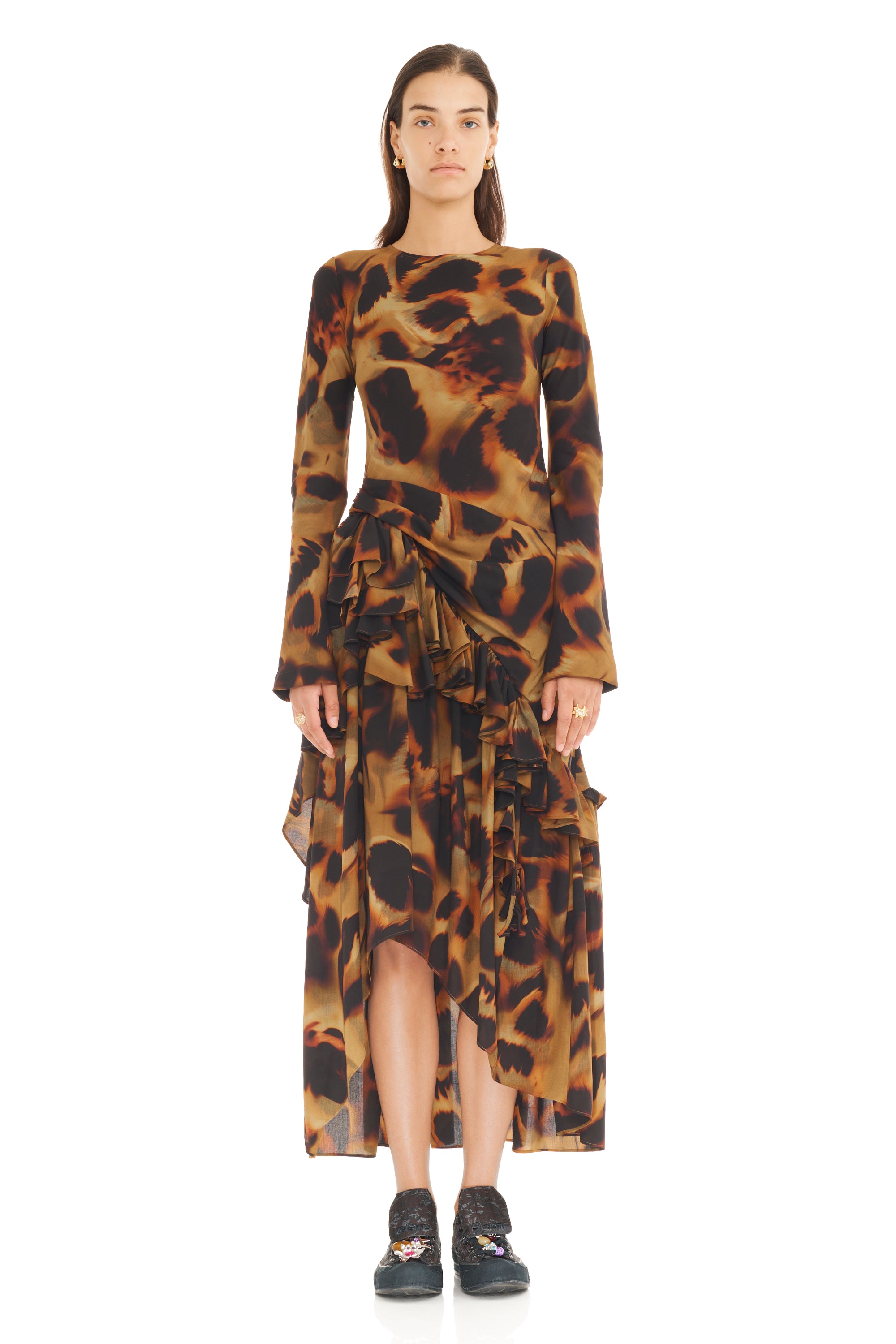 Model wearing a long-sleeve, patterned tortoise shell printed dress on a white background