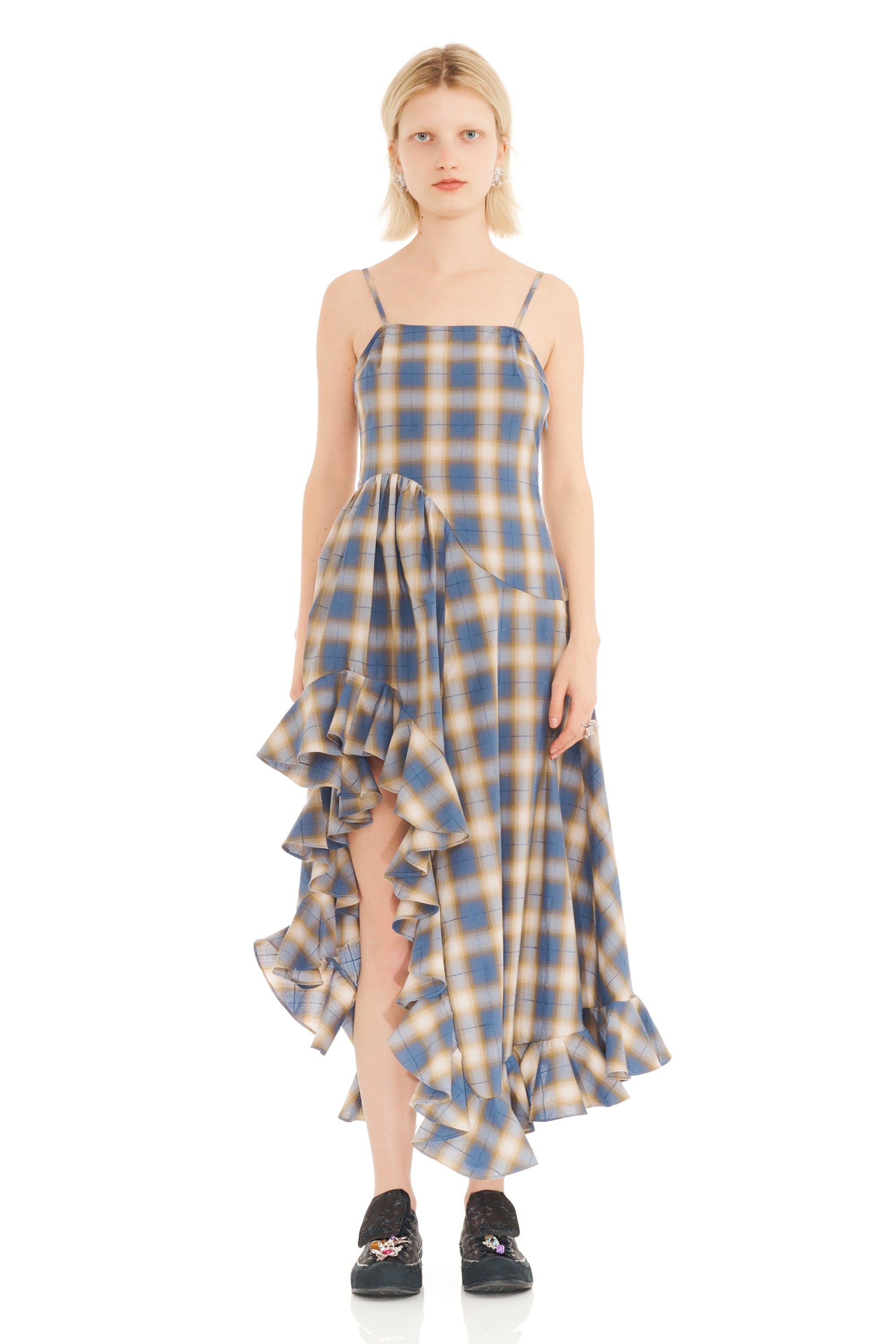 Woman wearing a blue and beige plaid dress on a white background