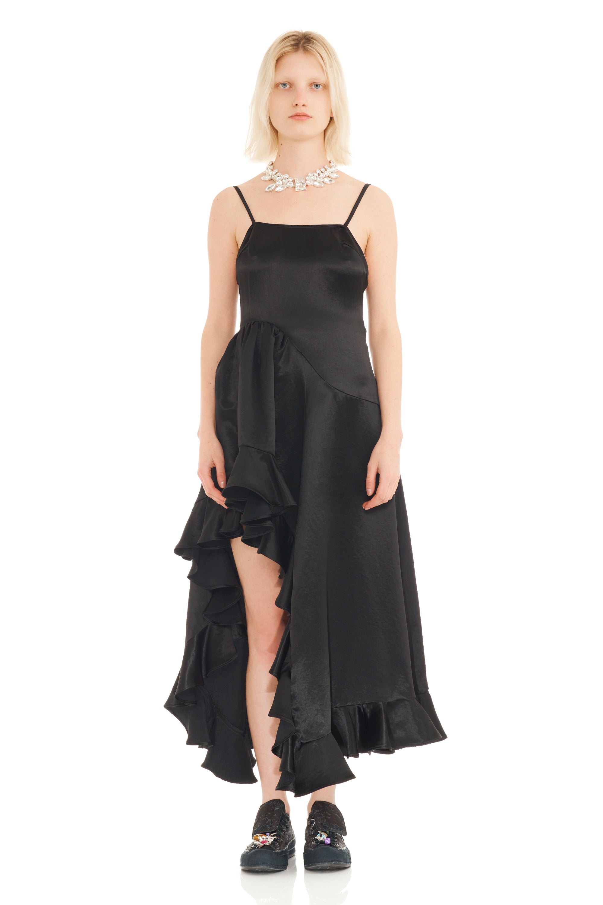 Woman wearing a black dress with ruffled layers on a white background