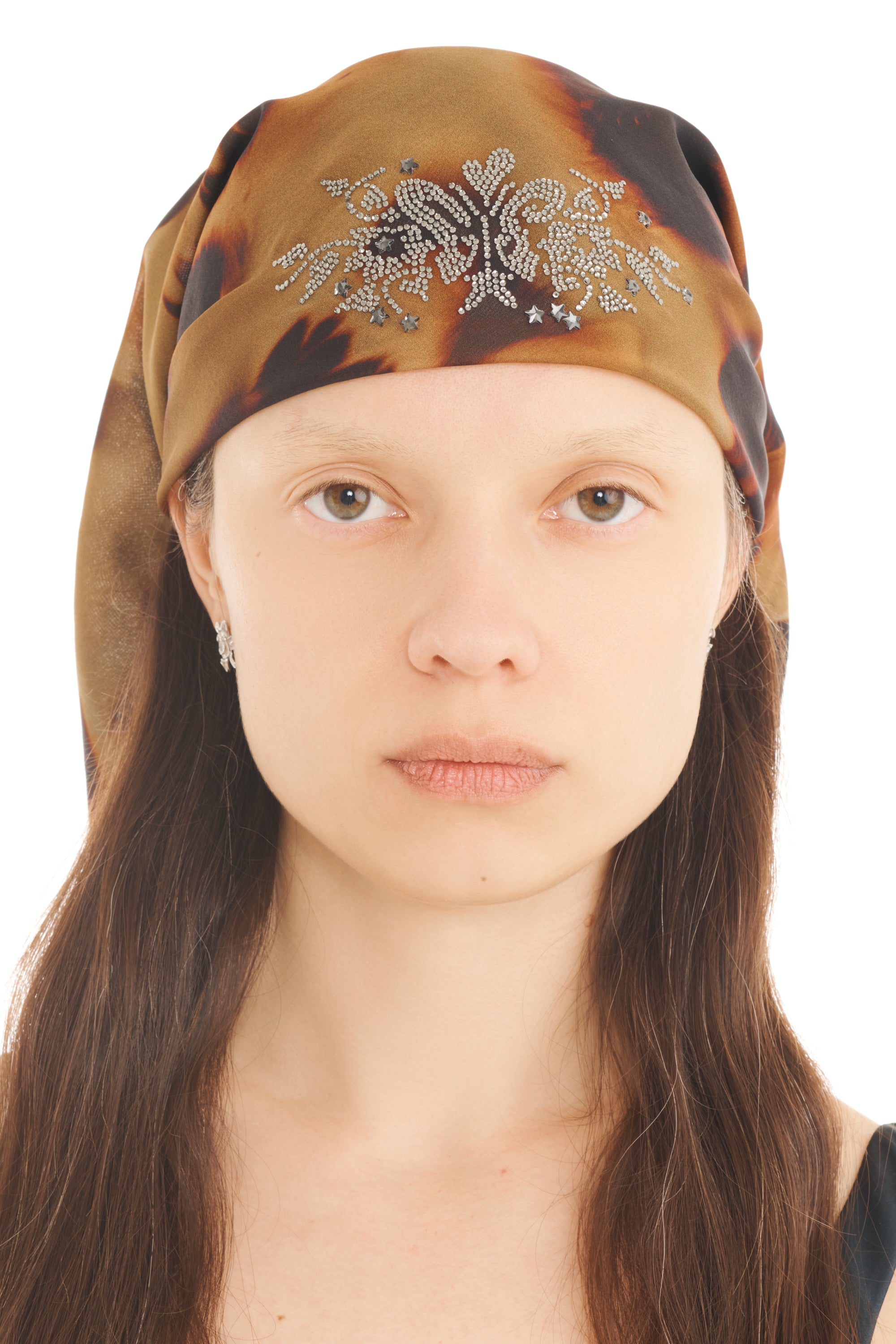 A model wears a tortoise printed foulard head scarf with rhinestone detailing on a white background