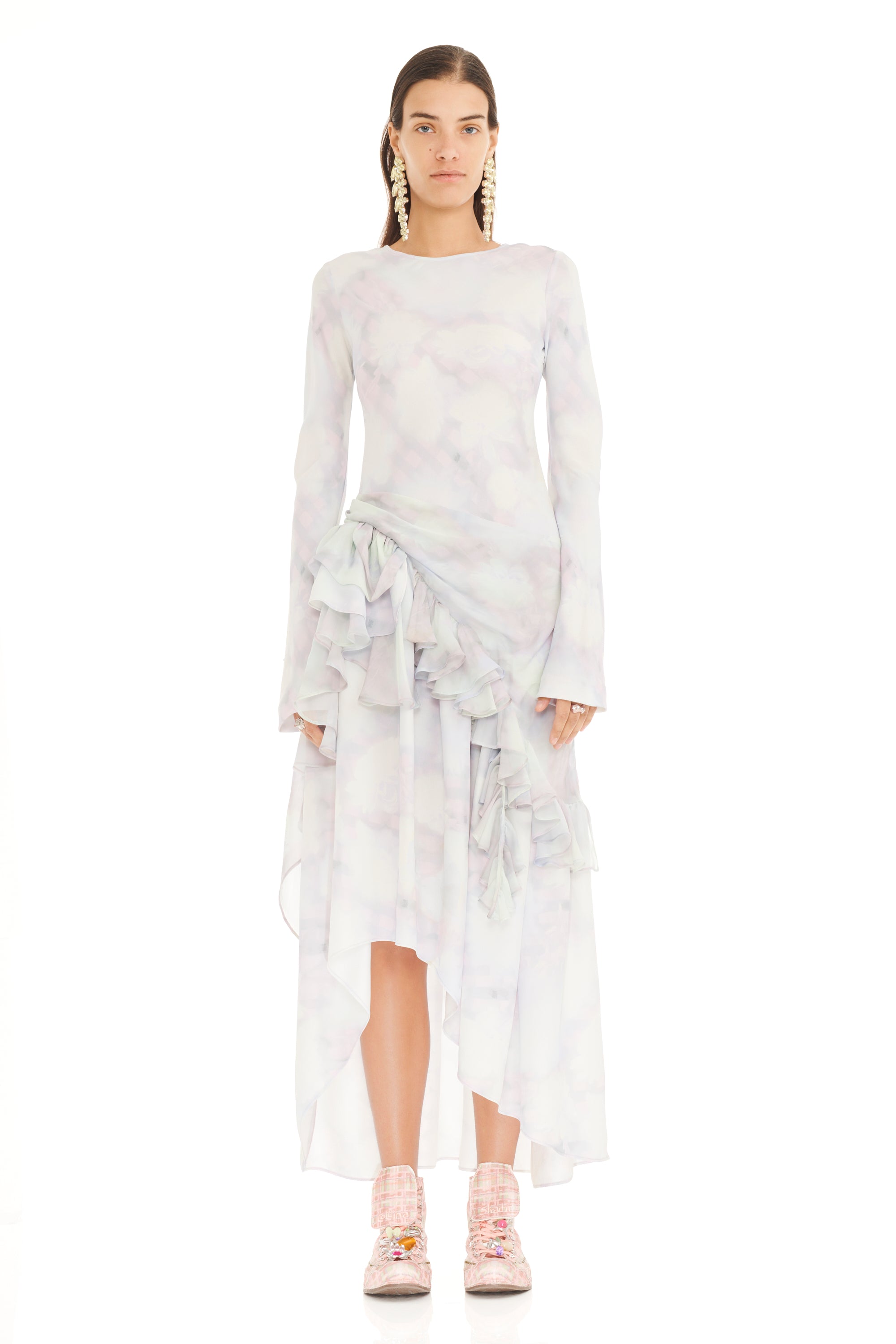 Woman wearing a white dress with ruffled details on a white background