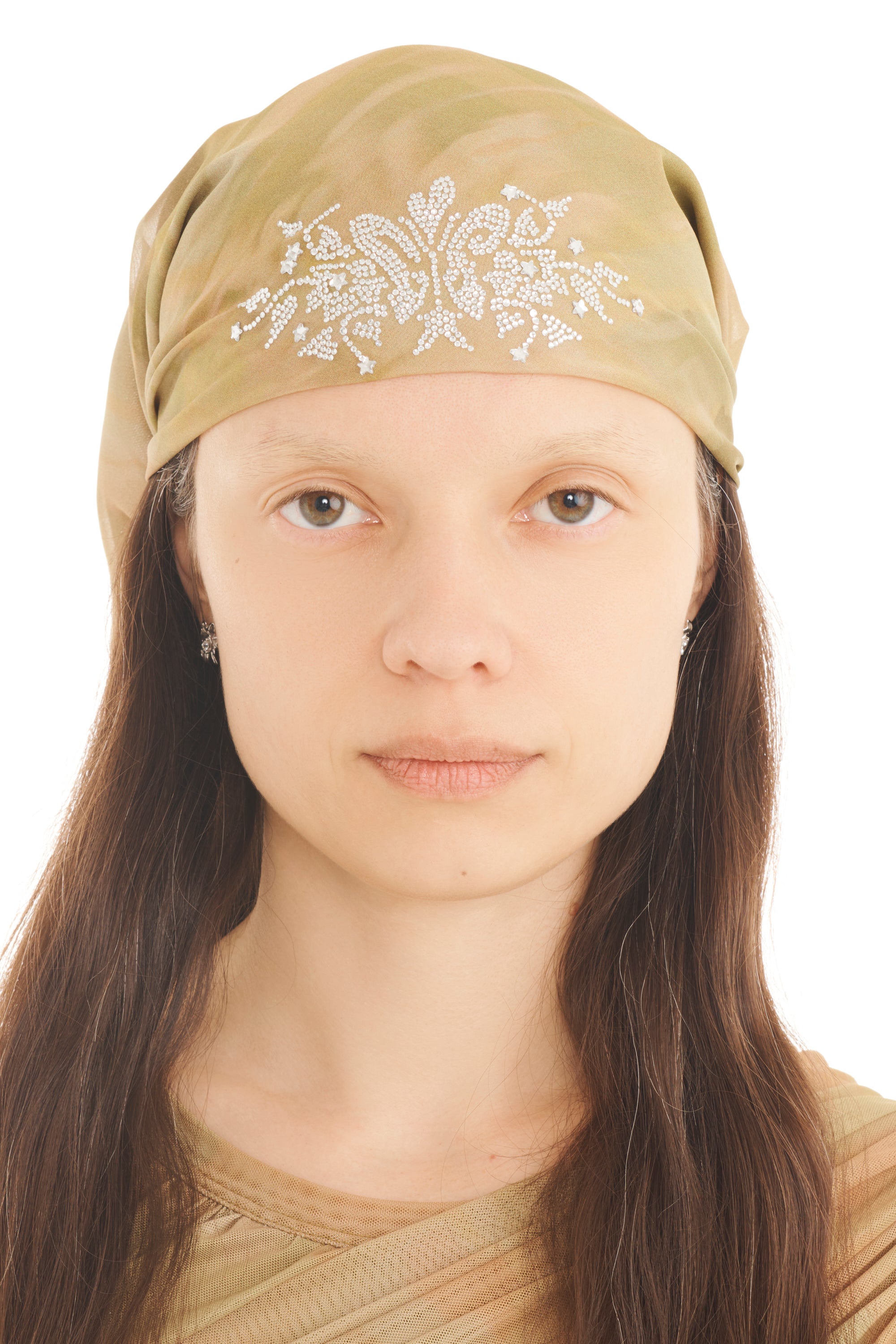 A model wears a beige printed foulard head scarf with rhinestone detailing on a white background